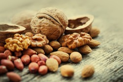 Almonds, walnuts and hazelnuts on wooden table / assortment of nuts