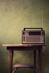 Old radio on rustic background in vintage color