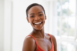 Portrait of beautiful african woman smiling and looking at camera. Portrait of middle aged black woman with a big grin. Carefree and cheerful lady smiling at home in the morning.