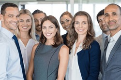 Portrait of successful group of business people at modern office. Happy businessmen and satisfied businesswomen standing as a team in office. Successful group of people smiling and looking at camera.