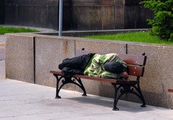 Homeless sleeping on bench during the day.