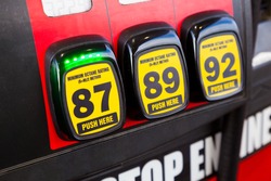 At a gas station multiple options are available for the type of gas to put in your vehicle and in this scenario the cheapest type of regular is selected since gas prices are rising and high.