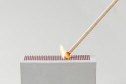 A Match being lit with the striking surface of a matchbox