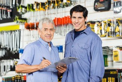 Portrait of happy father and son preparing checklist in hardware store