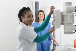 Radiologist Adjusting X-ray Machine Over Woman In Hospital