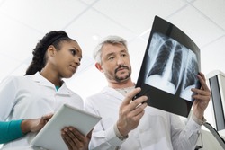 Radiologists With X-ray Using Digital Tablet In Hospital
