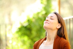 Relaxed woman breathing fresh air in a garden a sunny day at home