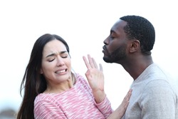 Disgusted woman rejecting a man who is trying to kiss her