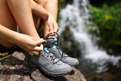 Close up portrait of a hiker tying shoe laces in the mountain