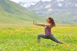 Profile of a woman practicing tai chi in a high mountain field