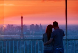 Couple in love at Paris admire Eiffel Tower at sunset