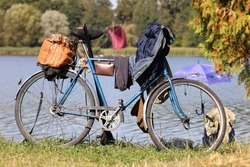 An old fisherman's bike on a beautiful lake. Fishing. Fishing gear, fishing rods, a bag for fish.