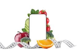 healthy food and beauty concept. Smartphone and fruits with vegetables and a measuring tape on a white isolated background