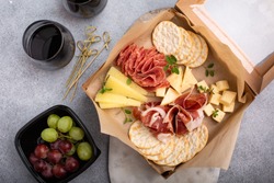 Cheese and meat assortment in a to go box, food delivery or catering concept