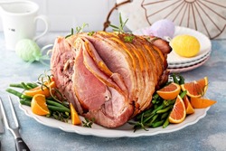 Traditional Easter ham spiral sliced with honey glaze stuffed with oranges and rosemary