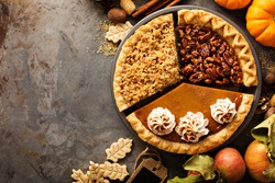 Fall traditional pies pumpkin, pecan and apple crumble pie overhead shot with copyspace