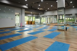 Spacious dance room with mirrors, yoga mats and bricks prepared for clients
