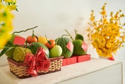 Basket of fresh seasonal fruits decorated with red bow prepared for spring festival