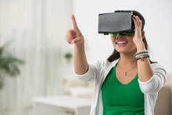 Asian woman playing game in virtual reality glasses