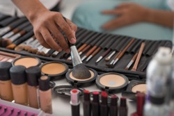 Make-up artist using natural animal hair brush to apply pressed powder