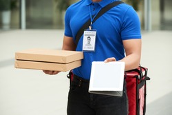 Cropped image of courrier giving you digital tablet to sign for the pizza delivery