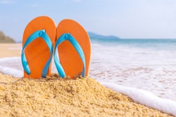 Summer vacation concept--Orange Flipflops on a sandy ocean beach