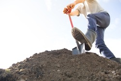 man digging the ground with shovel
