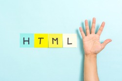 Concept of HTML5 on blue background and hand showing the open palm with 5 fingers. HTML5 is a language of the Internet.