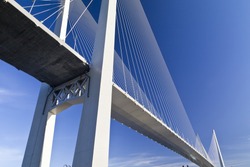 Big suspension bridge in beams of the coming sun against the blue sky