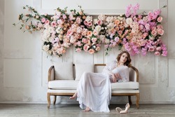 Woman in white boudoir dress in light floral interior