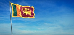 The National flag of Sri Lanka blowing in the wind in front of a clear blue sky. 3d illustration.