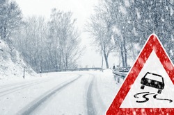 Snowy road with traffic sign  Sudden and heavy snowfall on a country road. Driving on it becomes dangerous Ã¢Â?Â¦ 