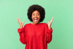 afro black woman feeling happy, excited, surprised or shocked, smiling and astonished at something unbelievable