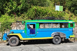 Filipino green-blue-yellow dyipni-jeepney car. Public transportation in Banaue town-originally made from US.military jeeps left over from WW.II locally altered-now from japanese surplus. Philippines.