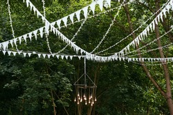 White flags and decor in the outdoor in the tree surroundings