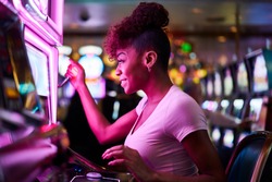 happy woman gambling at casino playing slot machine