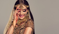Portrait of beautiful indian girl. Young hindu woman model with golden kundan jewelry set . Traditional Indian costume lehenga choli .
