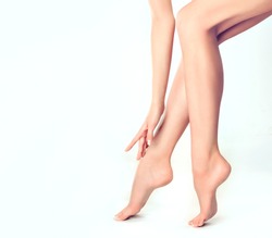 Beautiful well-groomed female legs . Foot care . Depilation of hair on the feet .