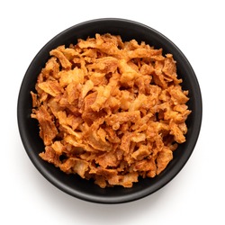 Crispy fried onions in a black ceramic bowl isolated on white. Top view.