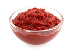Tomato paste in a glass bowl isolated on white.