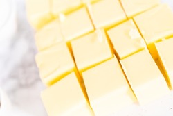 Unsalted butter sticks cut into cubes for preparing Italian buttercream frosting.