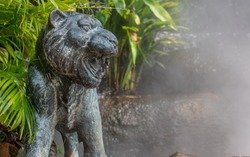 Lion in a misty garden at Wat Saket in Bangkok