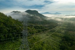 Aerial view Morning scenic on high mountains forest with electricity pylon Pang Puay, Mae Moh, Lampang, Thailand. Beautiful morning with golden sunrise and fog flowing.