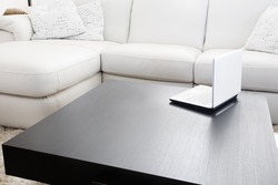 Modern livingroom. White furniture - sofa and couch with a laptop on table