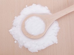 MSM pure powder in wooden spoon. It occurs naturally in some primitive plants, is present in small amounts in many foods and beverages and is marketed as a dietary supplement.