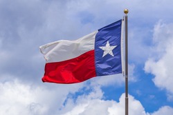 State of Texas flag against cloudy sky
