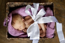 little cute baby in the box with a gift bow