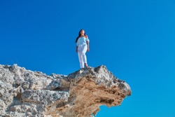 Lady looking up standing on high mountain. Relaxation or Modeling on Virgin nature. Woman posing on fresh air