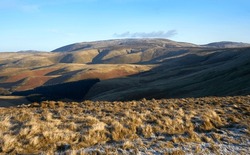 Views of The Cheviot from below the summit of Windy Gyle on a sunny winters morning in the Northumberland Cheviot mountains at sunrise, UK.