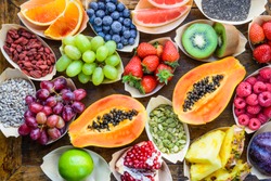 Healthy food fruits, berries, nuts, seeds top view on rustic wooden background.Diet, detox, superfood concept.